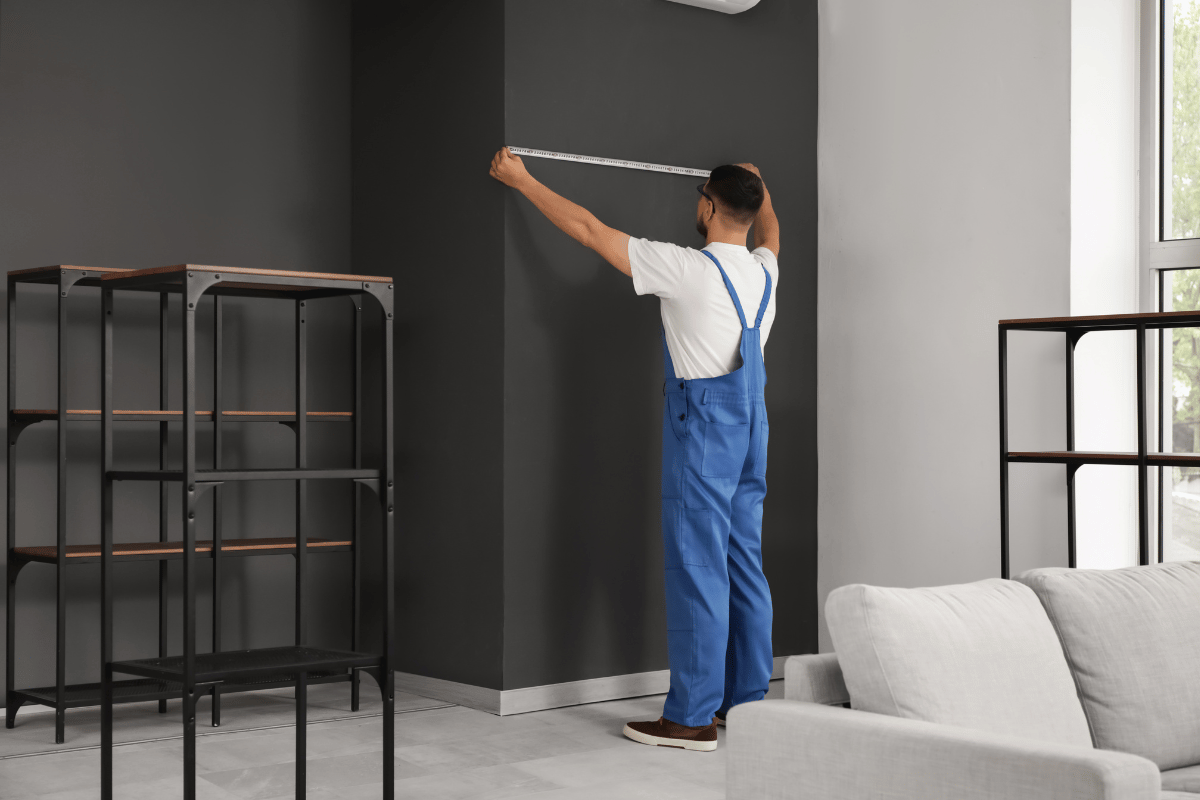 contractor measuring basement wall