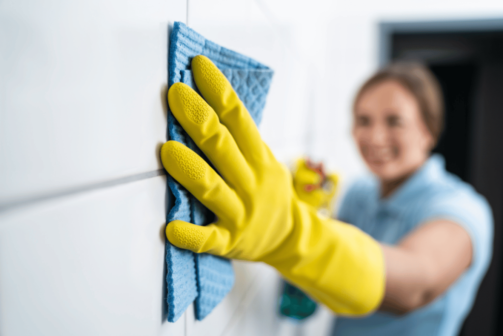 Person cleaning painted wall with soft cloth in modern home